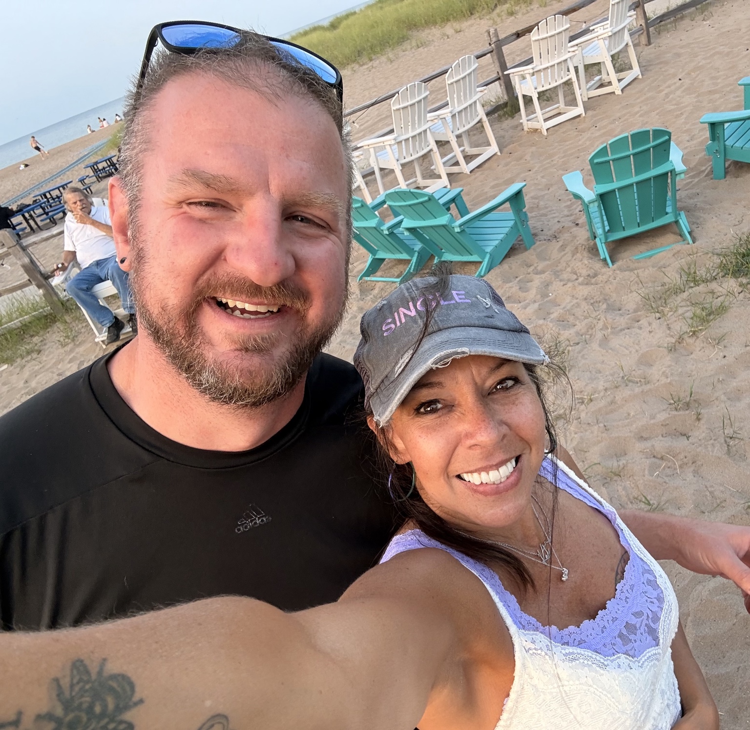 Two smiling attendees taking a selfie at a beach event