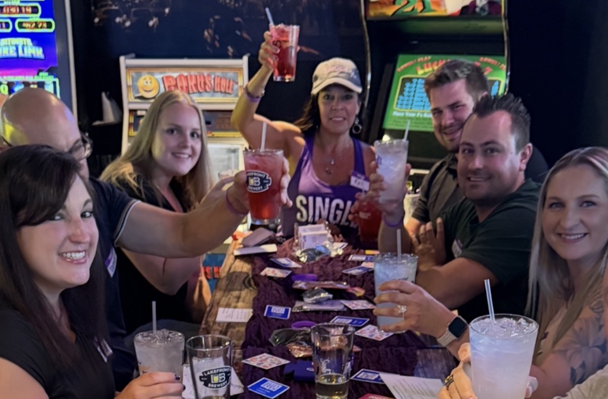A group of attendees raising their drinks together at a mingle event
