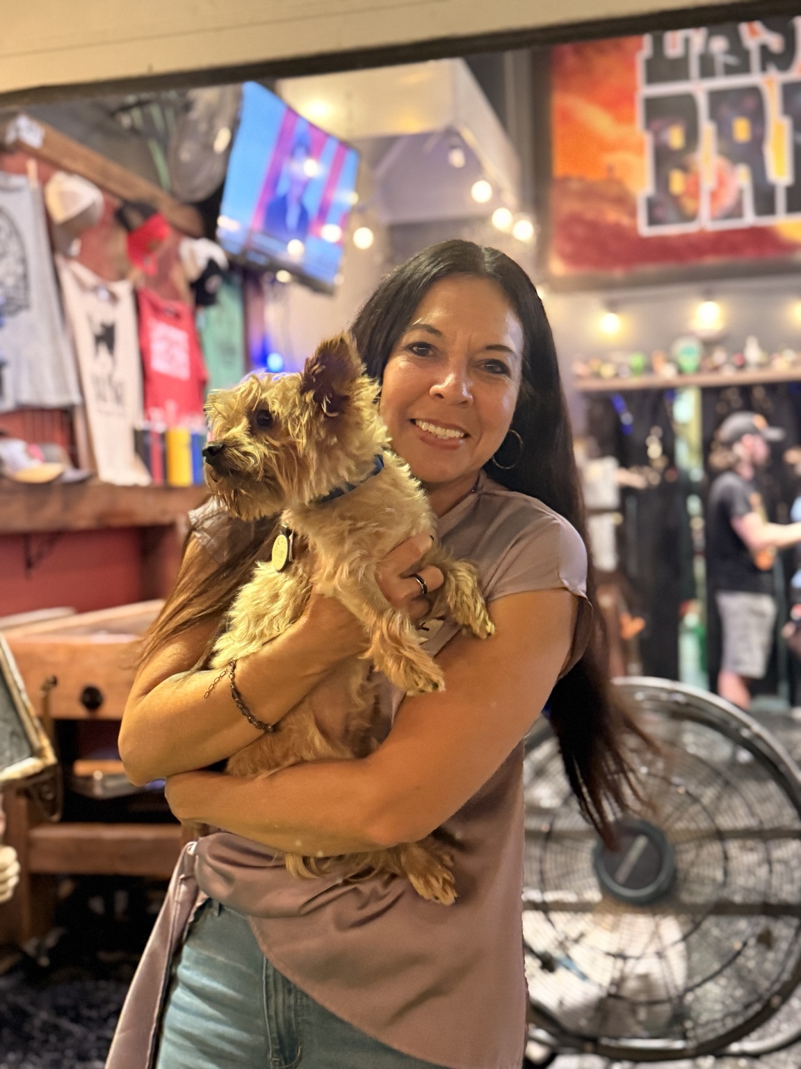 Kat smiling while holding Elliot at a local venue